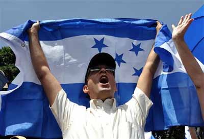 A demonstrator waves the Honduras flag