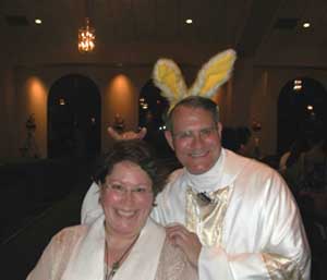 A smiling priest wearing bunny ears