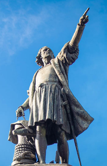 A heroic statue of Columbus pointing to the horizon