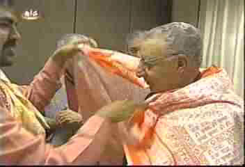 The Bishop receives a shawl covered in pagan verses
