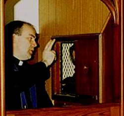 A priest gives absolution in a traditional confessional