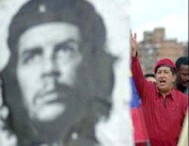 Hugo Chavez stands behind a picture of Che Guevara