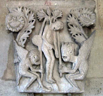 a carving of Judas being hung by devils