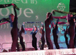 Dancers in black bodysuits perform at a youth conference