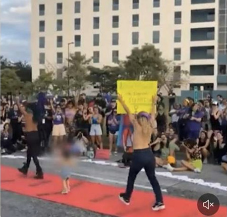 Topless feminists with a little topless girl in a protest