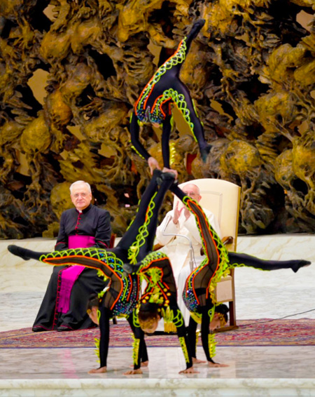 Acrobats in partially transparent leotards perform in front of Pope Francis I