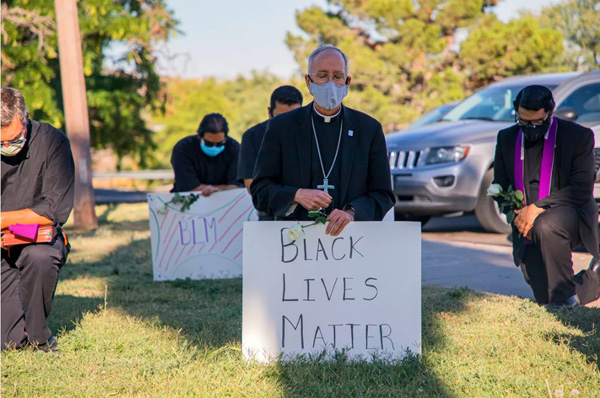 Bishop Mark Seitz kneels to BLM