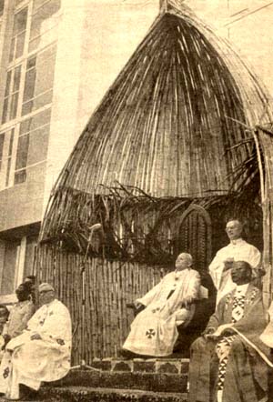 John Paul II sitting under a bamboo hut in Africa