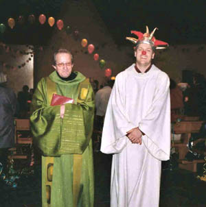 A clown acolyte stands beside a priest