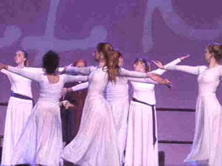 Dancing girls in semi-transparent dresses on stage in Church