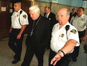 Cardinal Law escorted to the courtroom