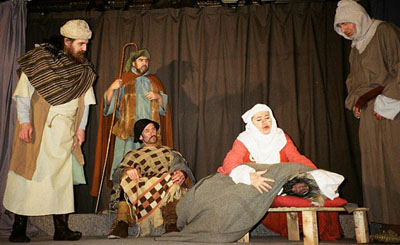 A scene from the play where shepherds find the sheep in a cradle