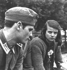 A photograph of two a young soldier and a young woman with a white flower